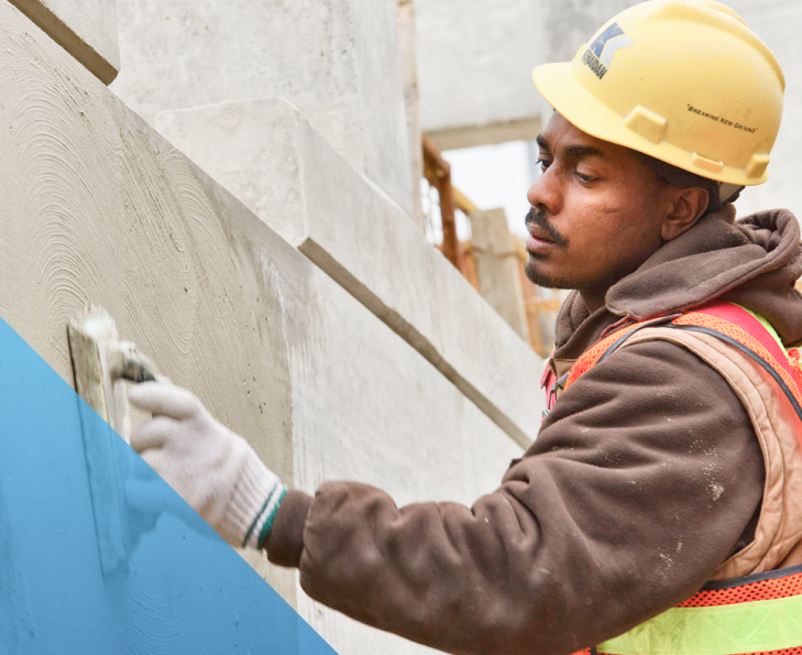 construction worker wearing PPE and applying concrete