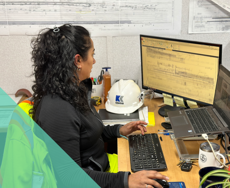 a female sitting at a desk and using a computer