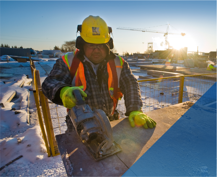construction worker wearing PPE and using a power tool